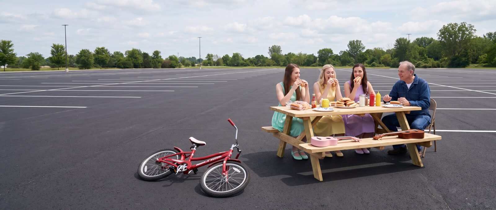 The Diddle family sharing a meal at a picnic table in an open field.